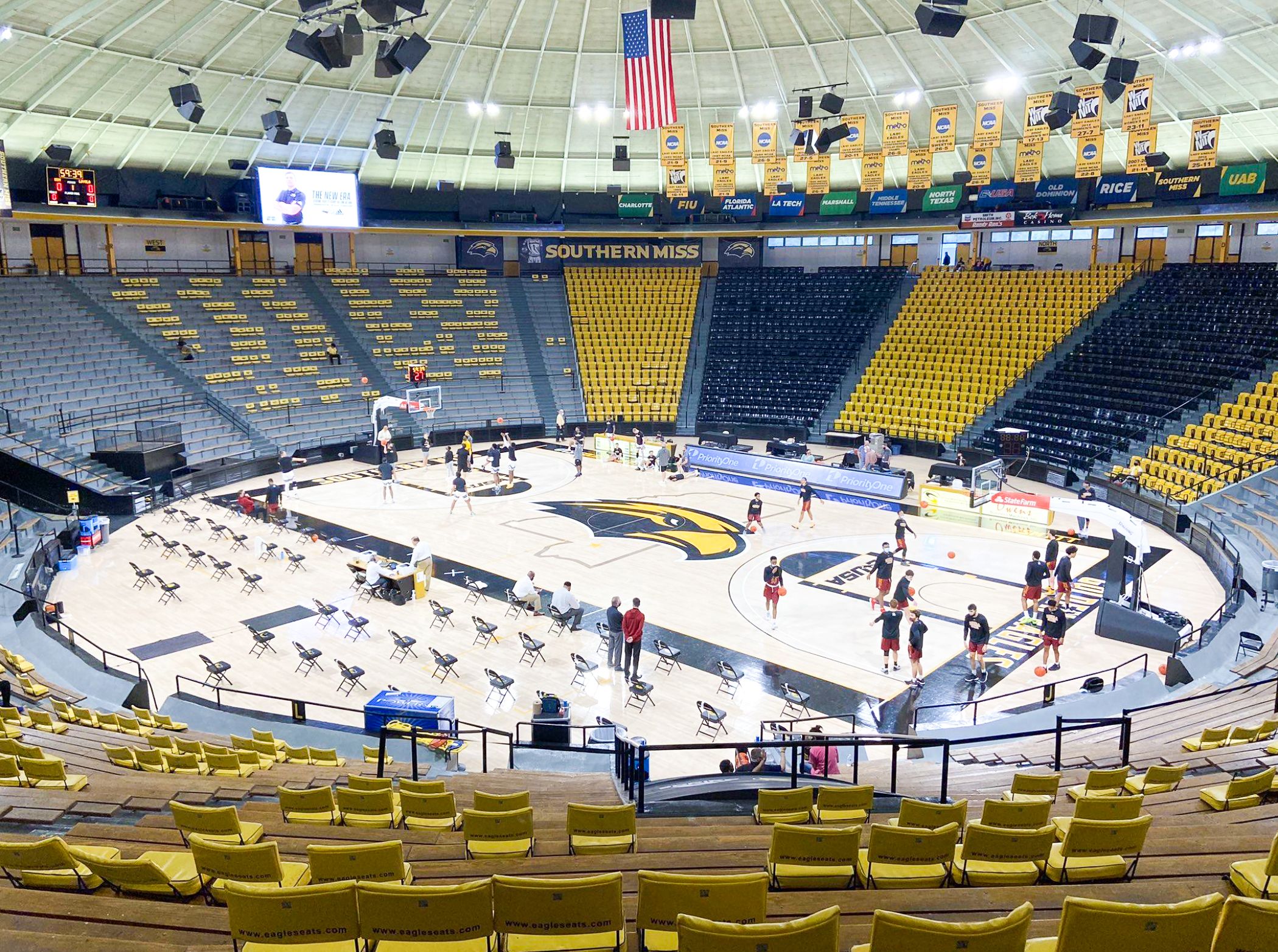 Southern Miss Golden Eagles basketball court by Sports Floors, Inc. at Reed Green Coliseum, with a glossy hardwood floor, a gold-and-black eagle logo at center court and black-and-gold painted lanes, seen from the upper seating bowl
